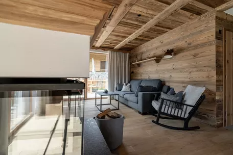 Wohnzimmer mit Altholzfassade Ofen graue Möbel