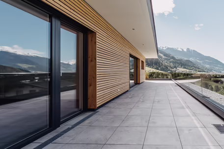 Holz-Alu Fenster eingebettet in der schönen Holzfassade