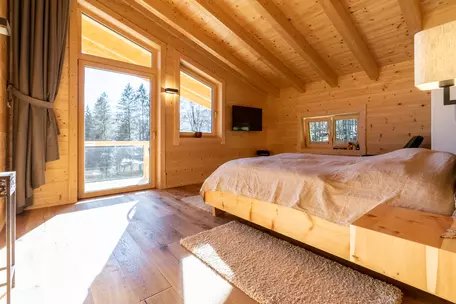 Schlafzimmer mit Wänden und Decken aus Holz